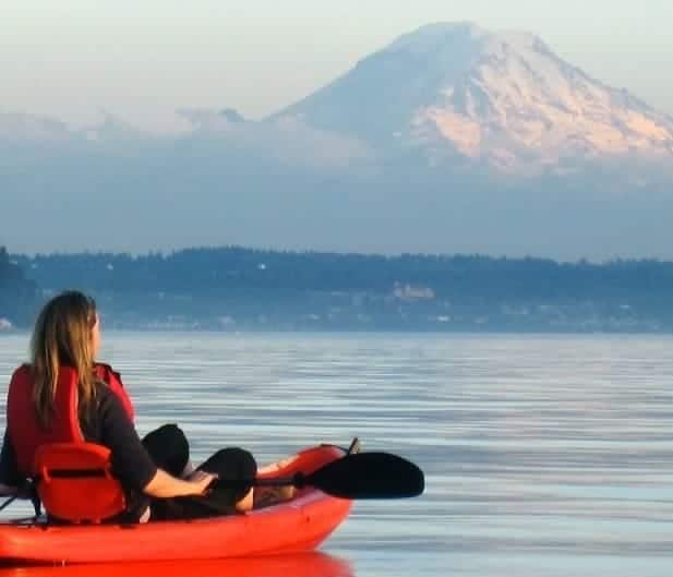 woman in kayak gazing toward mountain